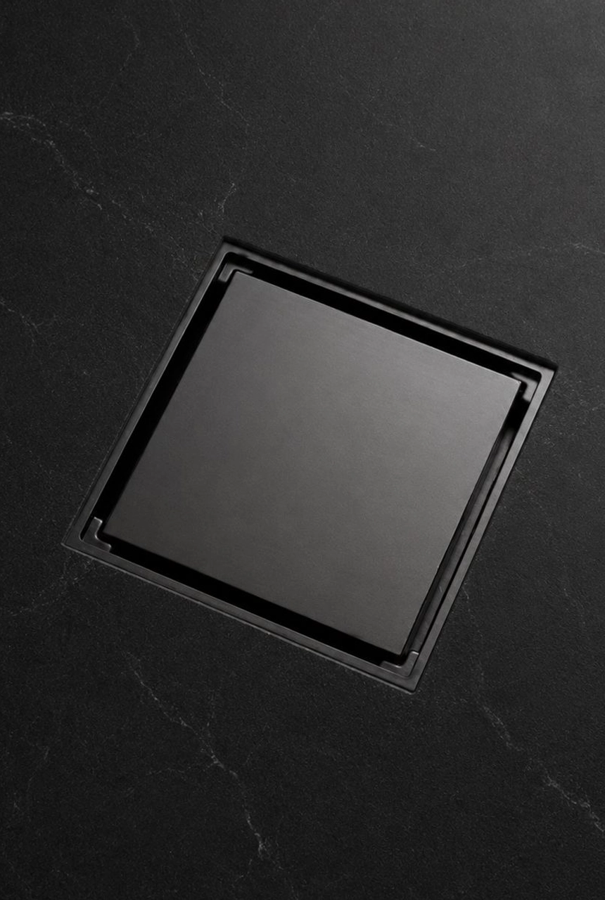 X4 Design and Build black marble bathroom floor with square floor trap, zero joint style surface, dark stone finish, and modern drainage detail